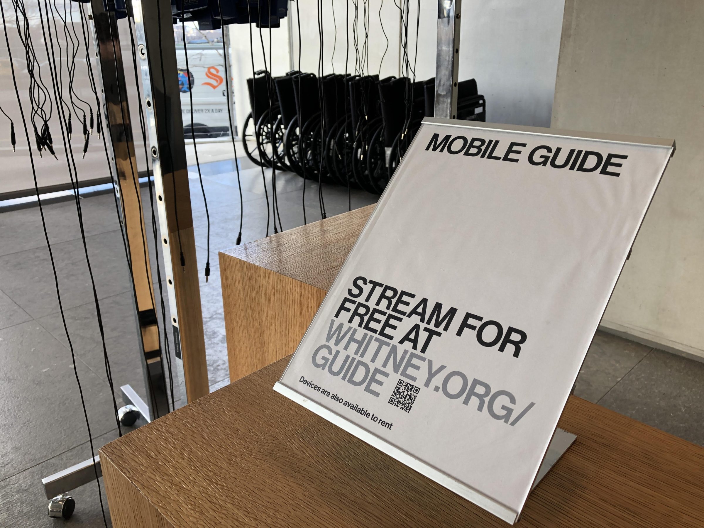 Stanchion sitting on a counter in the lobby of the museum directing visitors to the Mobile Guide.